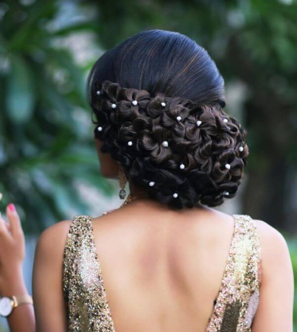 Pearl bun hairstyle in the shape of multiple flowers for bride or bridesmaid