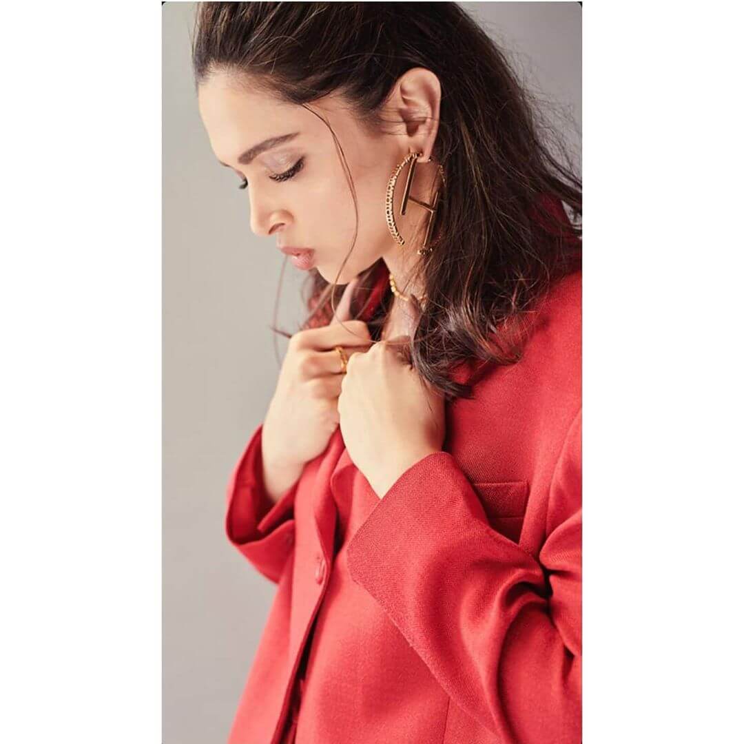 Deepika Padukone’s red blazer with golden bracelet, earrings and a neck piece.