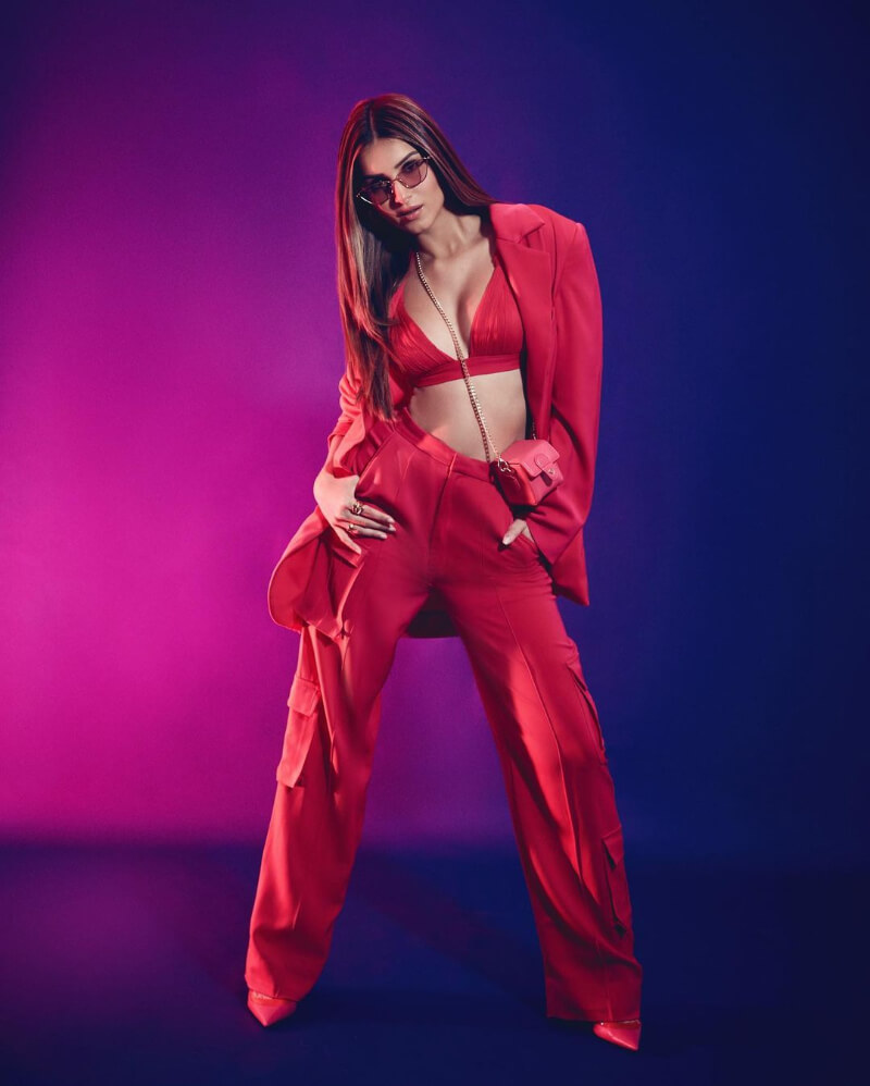 Actress Tara Sutaria in red pantsuit combined with a sexy V-neckline bralette