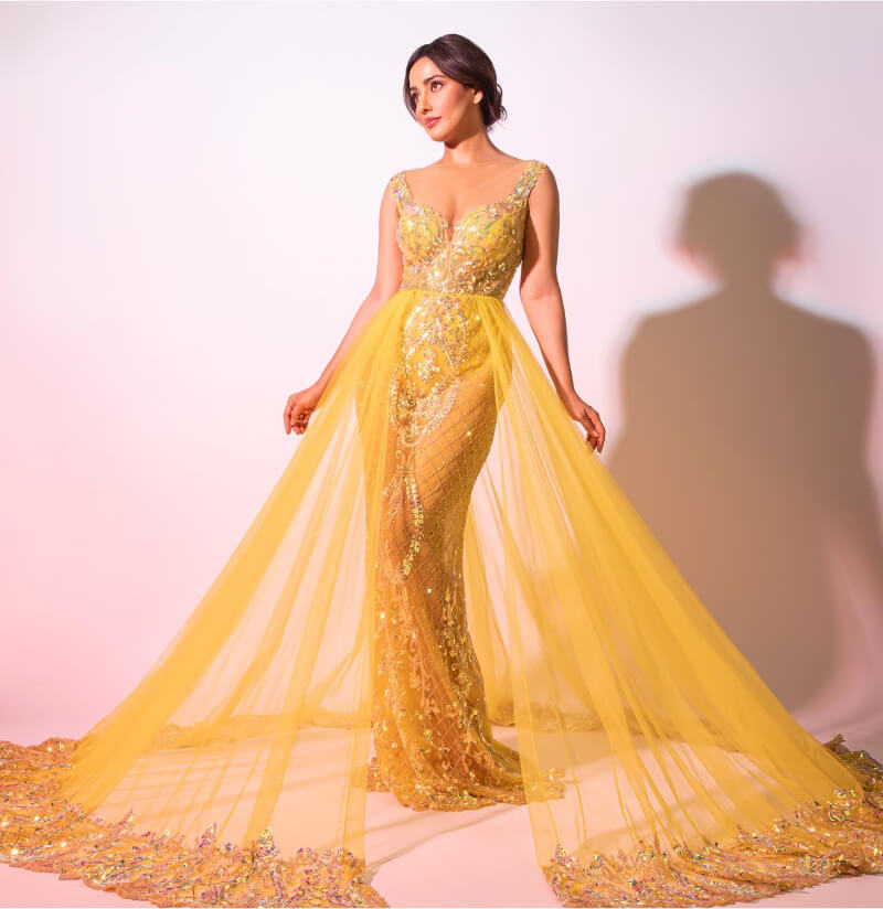 Bollywood Actress Neha Sharma in yellow embellished semi-sheer gown with a long trail
