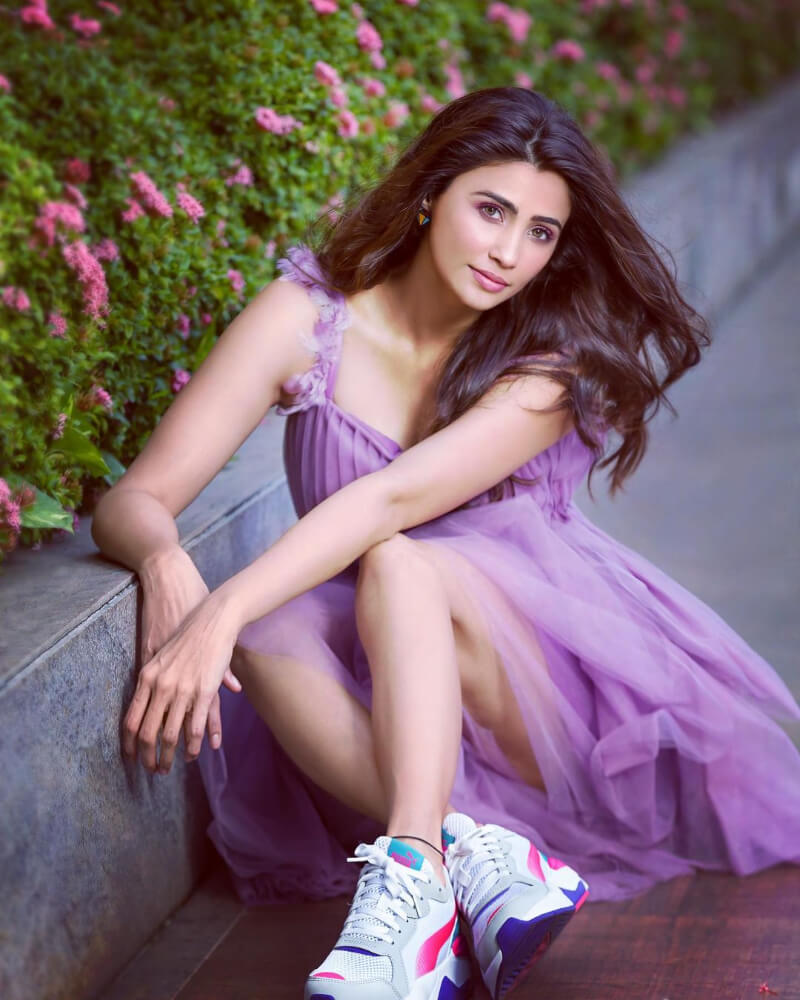 Daisy Shah looks stunning in a purple ruffled mini dress with sports shoes