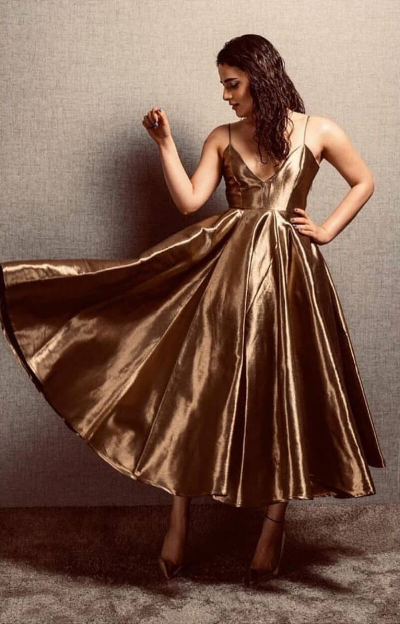 Radhika Madan in metallic gold flare midi dress with deep neckline
