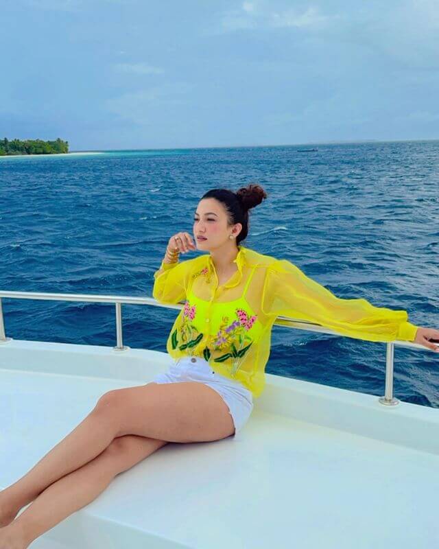 Actress Gauahar Khan chilling in in yellow transparent shirt with white shorts