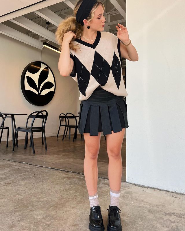 Brec Bassinger in Cool And Comfy Black & Creamy Check Sweater And Black Skirt Styled With Black Headband