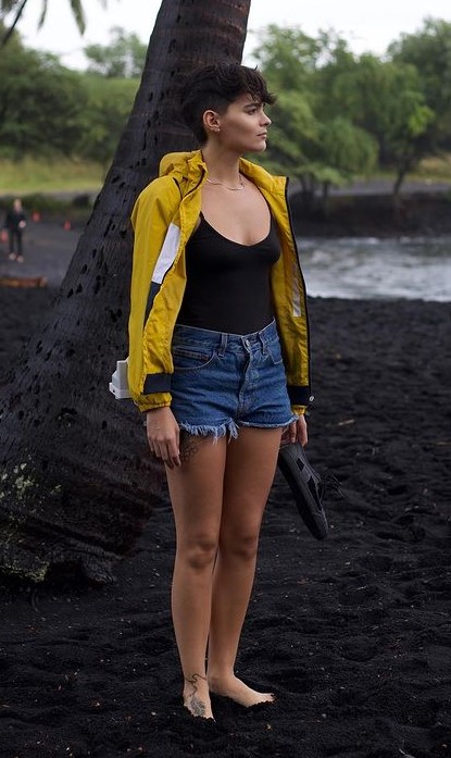 Brianna Hilderbrand's Beach Side Outfit In Black Top And Orange Jacket With Blue Denim Shorts