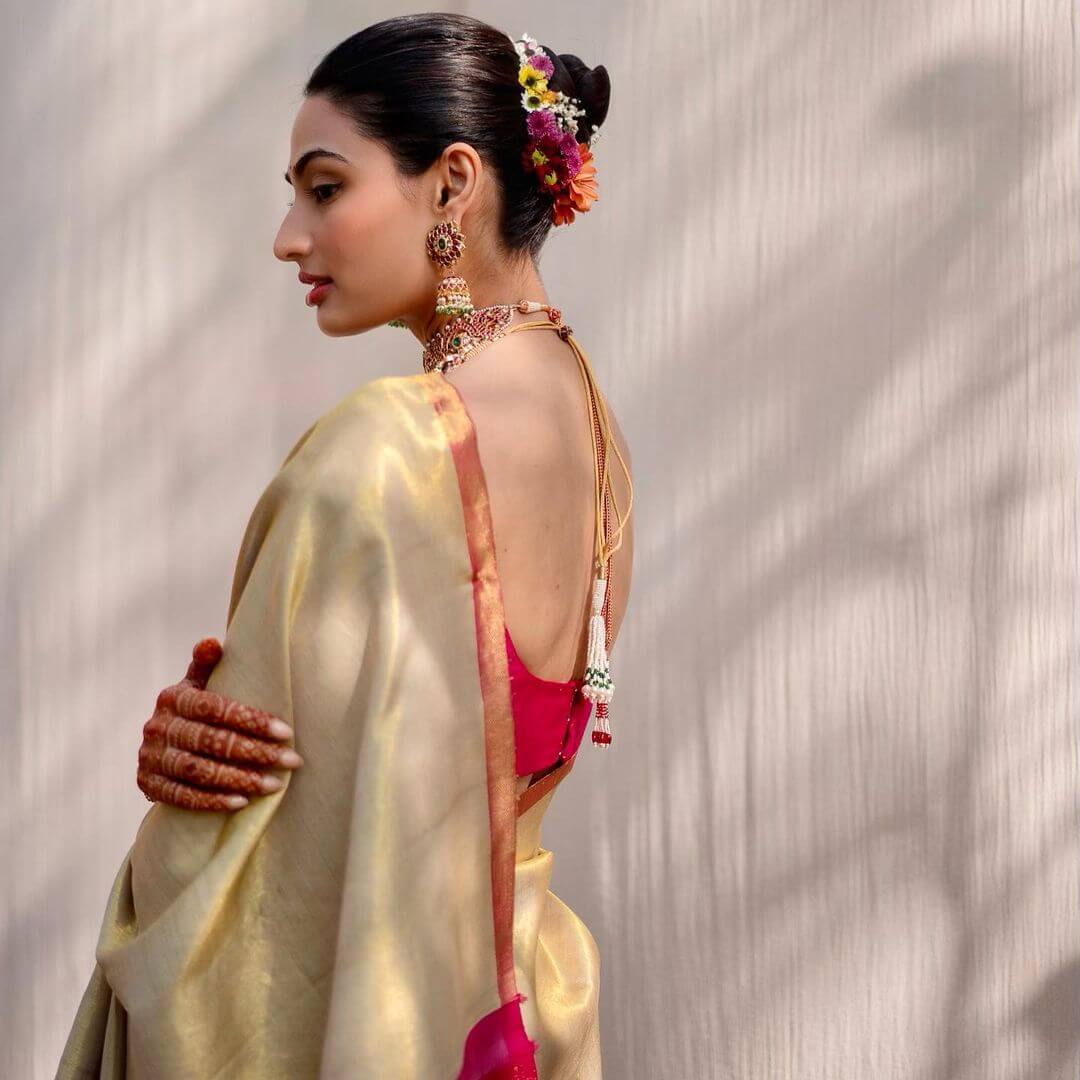 Athiya Shetty is a traditional Kannada bride as she opted for a plain gold handwoven tissue kanchipuram saree with a fuchsia pink blocked pallu from Madhurya 