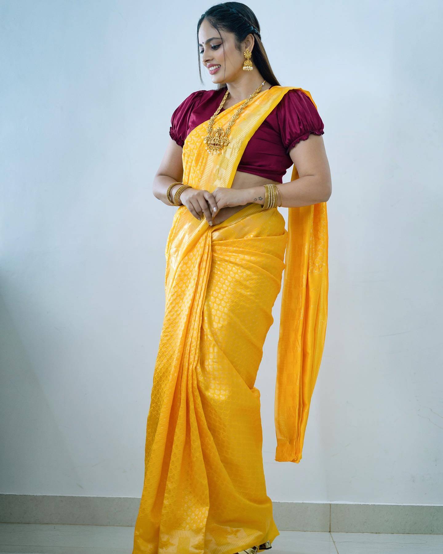 Nandita Swetha Flattering Look In Yellow Silk Saree Paired With Purple Puffed Sleeves Blouse