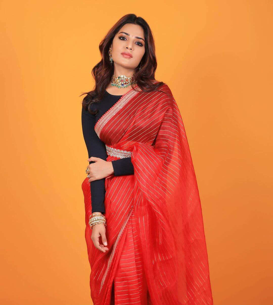 Aathmika In Red Saree With Golden Stripes Paired With Black Full Sleeves Blouse