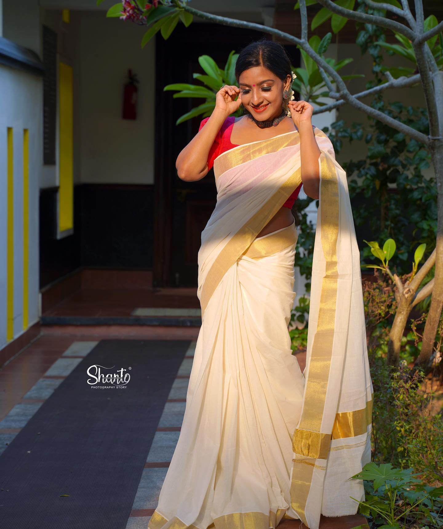Alphy Panjikaran  Slaying The Ethic Look In White Saree With Red Blouse With Bun Hairstyle