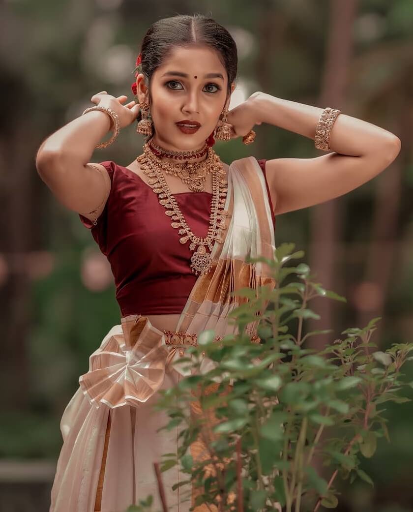 Anikha Surendran In Traditional White & Golden Saree & Red Blouse Paired With Gold Jewellery
