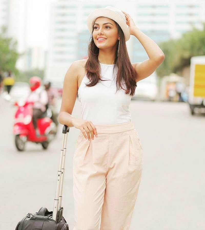 Anisha Ambrose In Her Vacay Look Wearing Pink Trouser With White Halter Neck Sleeveless Top & Styled With Chic Pink  Blower Hat