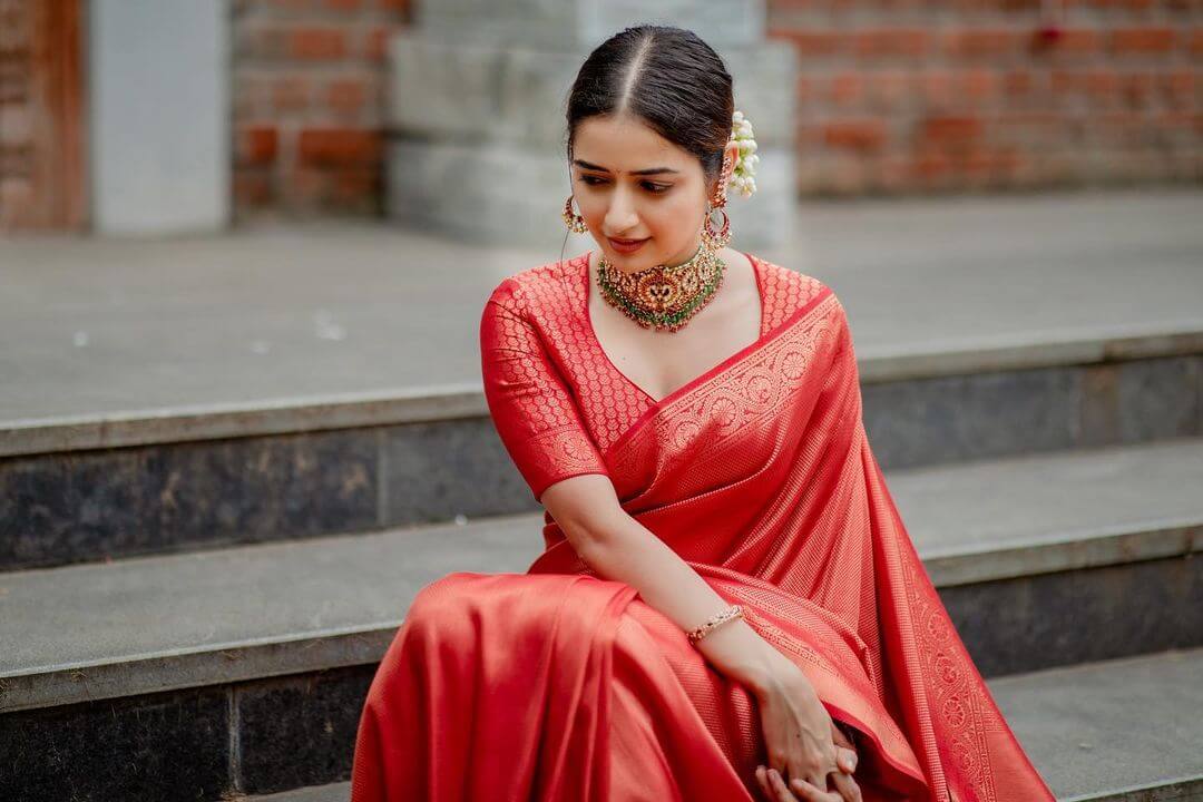 Ashika Ranganath Gives Us Newly Bride Vibes In Red Banarasi Saree With Heavy Gold Choker Necklace