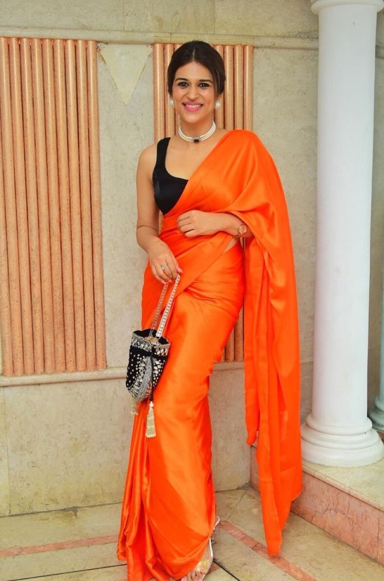 Shraddha Das In Orange Solid Saree Paired With Sleeveless Black Dupatta & Pearl Choker