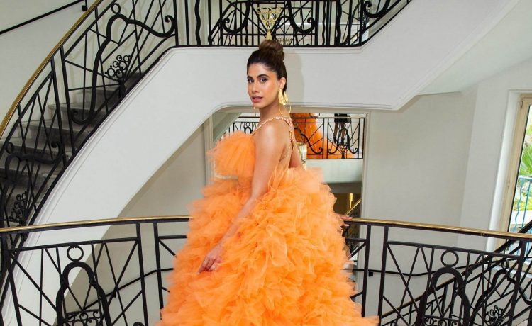 Social Media Personality Malvika Sitlani Cannes Look In Orange Full Ruffled Gown With Sleek Hair Bun
