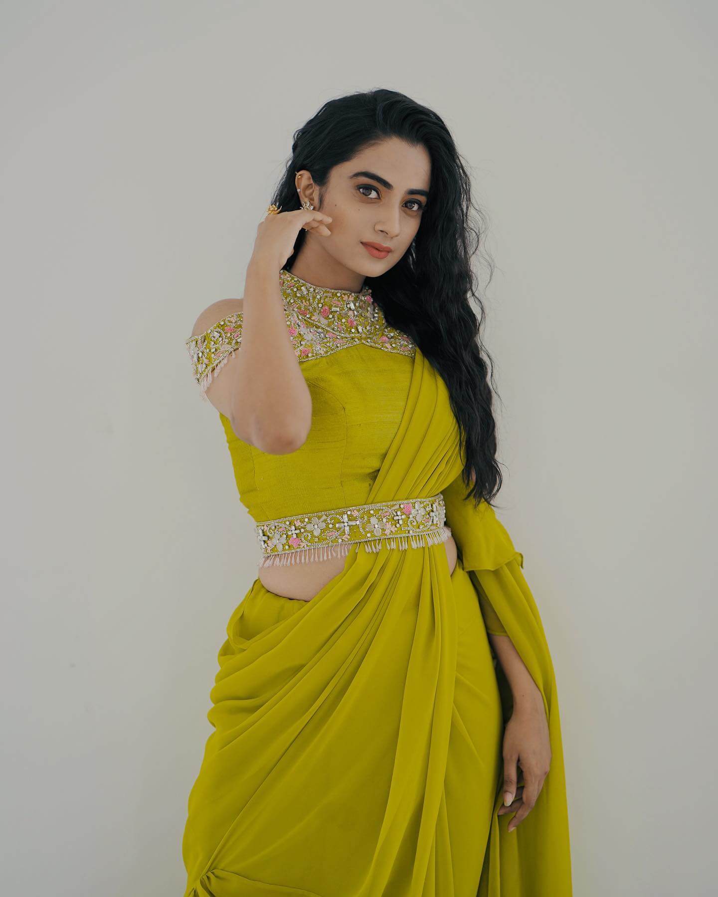 South Actress Namitha Pramod In Lime Green Ruffled Saree With Odd Shoulder Halter Neck Embellished Blouse & Waist Belt