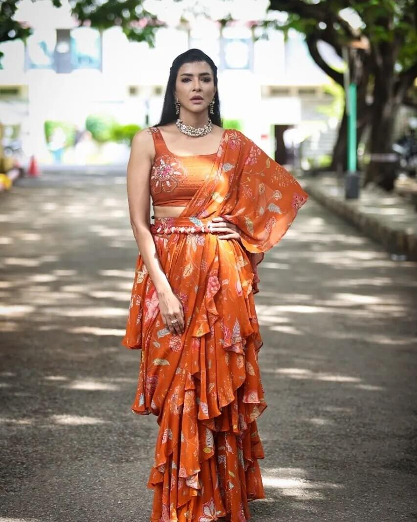 Manchu Lakshmi In Rusty Orange Printed Ruffled Saree With Monochrome Blouse 