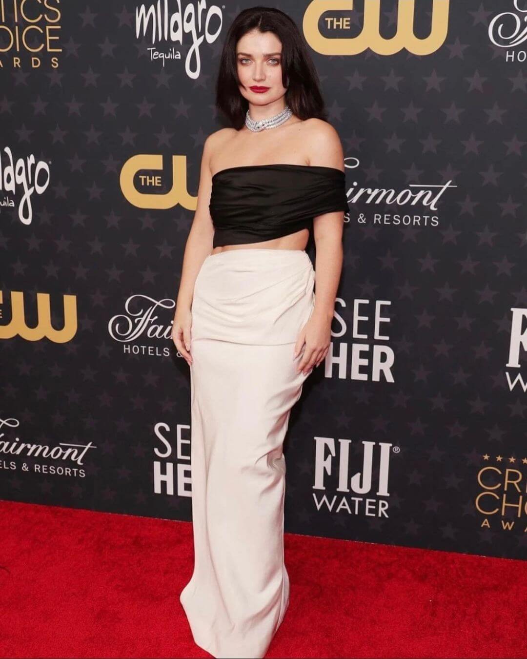Eve Hewson Turns The Head On In Critics Choice Awards In Black Off Shoulder Draped Crop Top With Beige Long Skirt