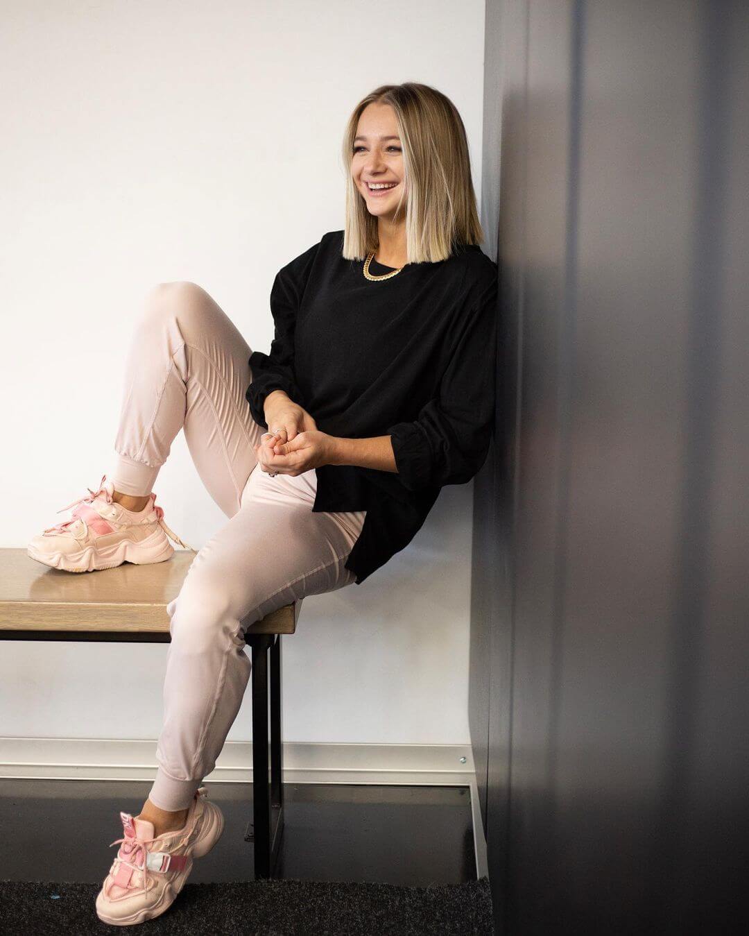 Mollee Gray In Her Casual Look Wearing Black Pullover With Beige Pants Styled With Peach Sneakers