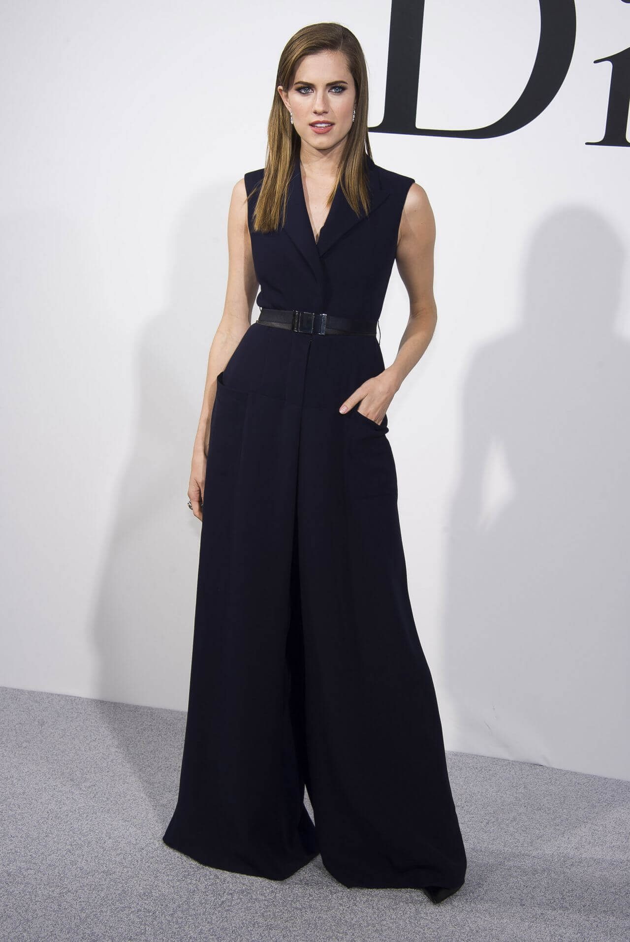 Allison Williams - In Navy Blue Sleeveless Flared Jumpsuit With Black Belt
