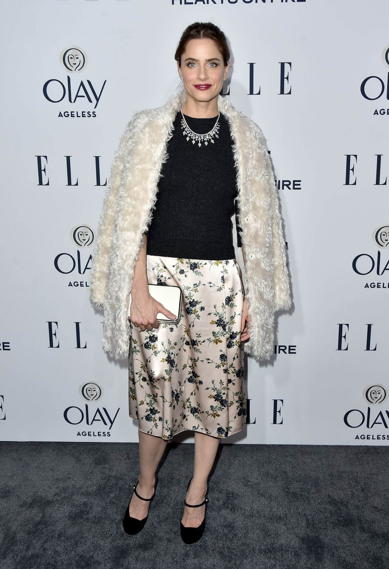 Amanda Peet In White Fur Coat Under Black Top & Printed Skirt With Diamond Necklace At  ELLE’s Women in Television Celebration in Los Angeles