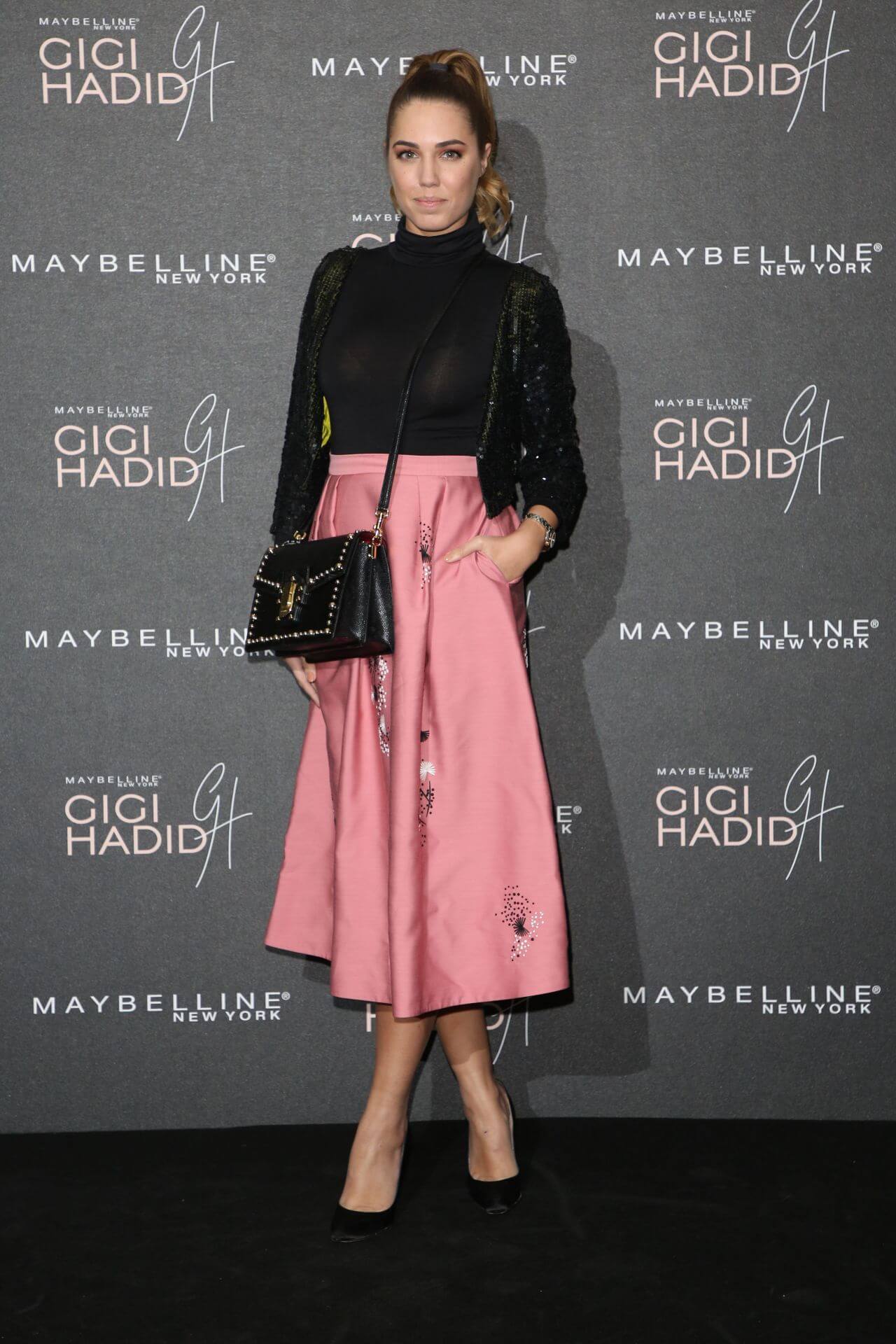 Amber Le Bon In Black Shiny High Neck Top With Pink Skirt Outfits At Gigi Hadid X Maybelline Party in London