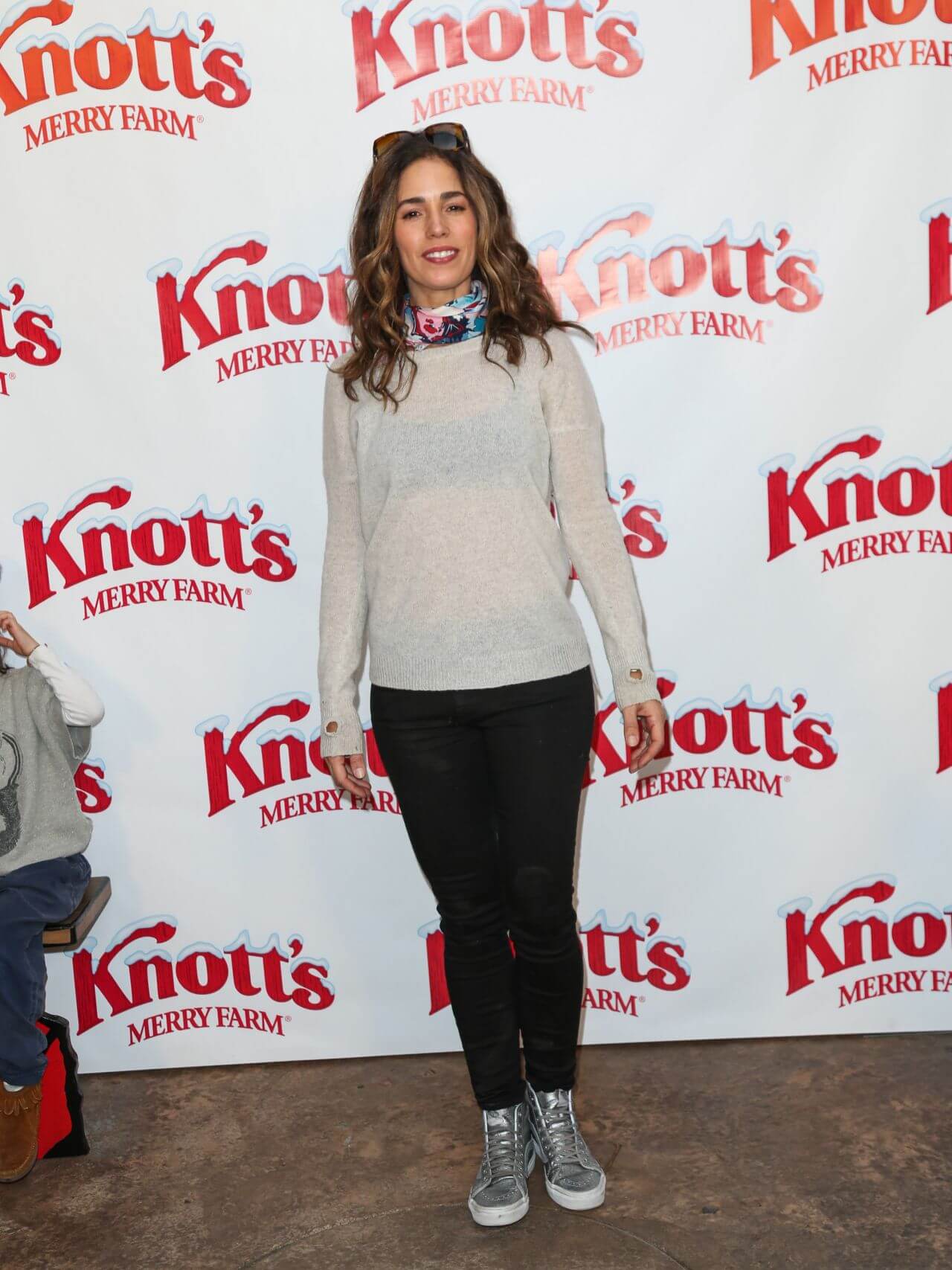 Ana Ortiz In Off White Woolen Sheering Top With Black Jeans & Colorful Neck Scarf At Knott’s Merry Farm Countdown to Christmas & Tree Lighting