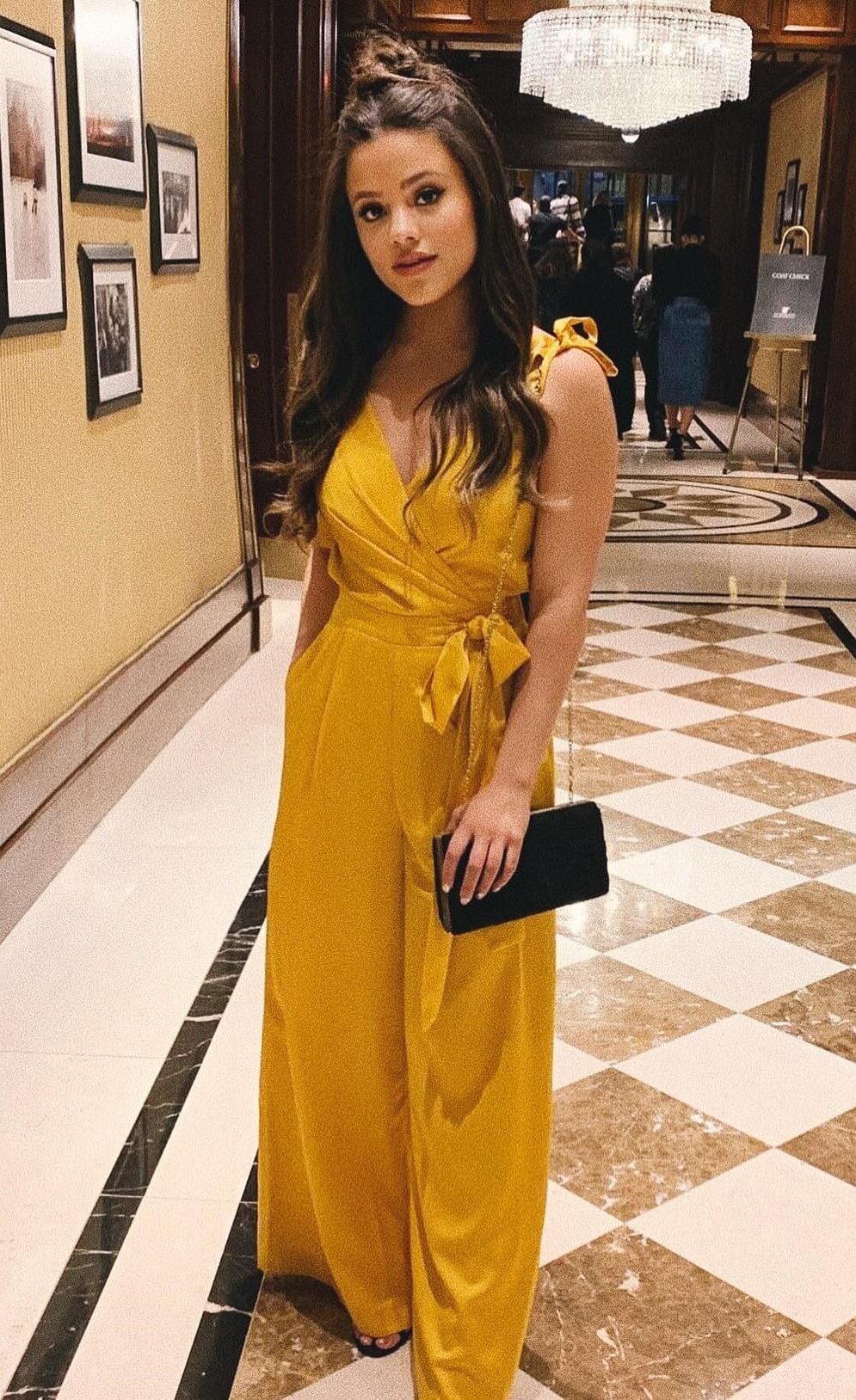 Sarah Jeffery In Yellow Sleeveless V Neck Flare Jumpsuit