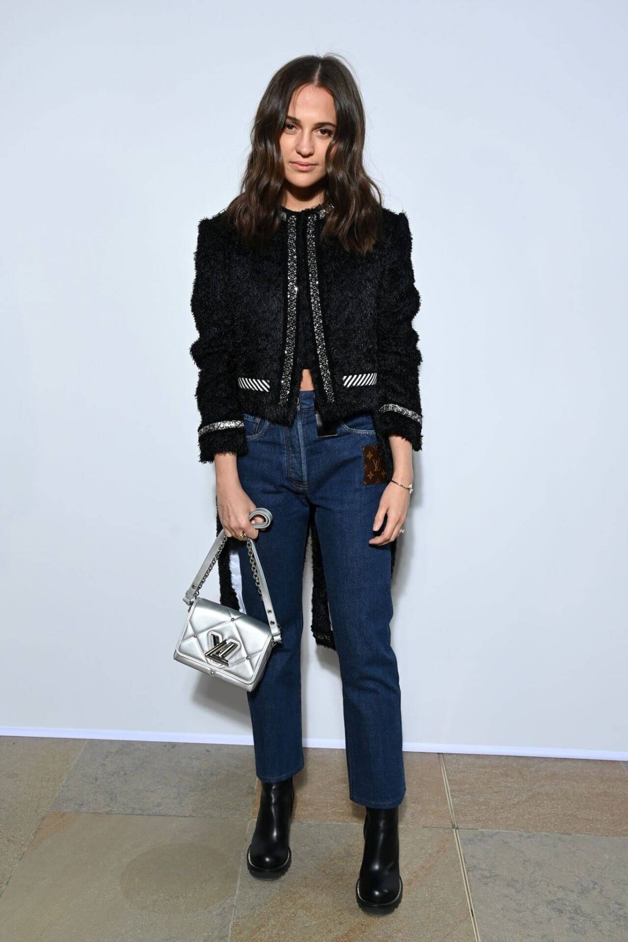 Alicia Vikander In Black Fur Coat & Blue Denim Jeans With Silver Handbag