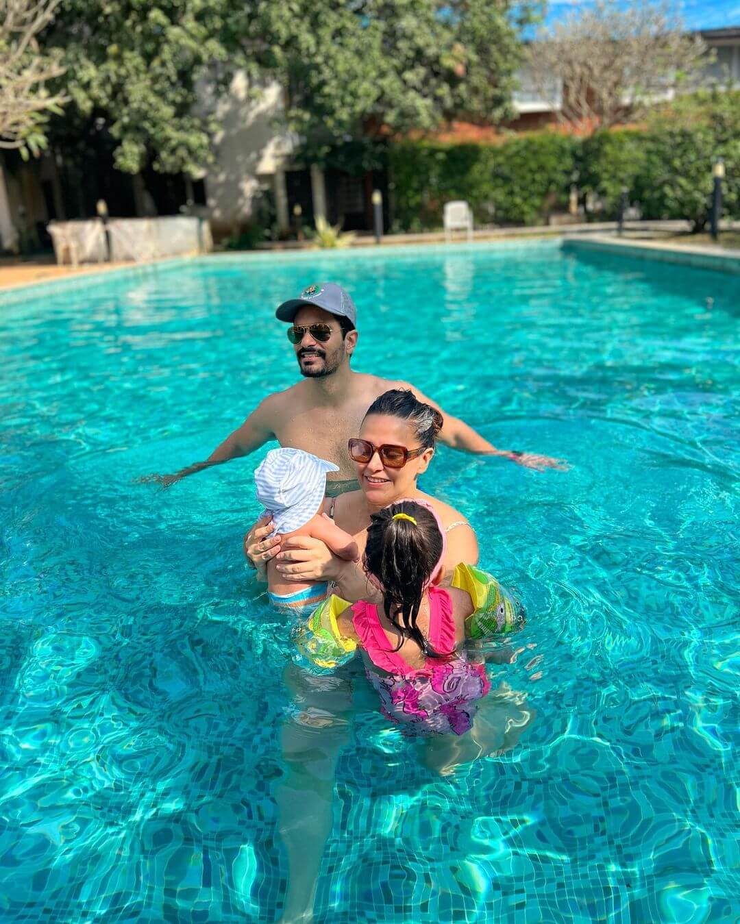 Neha Dhupia And Angad Bedi Enjoying In The Pool With Their Kids In Swimming Costumes