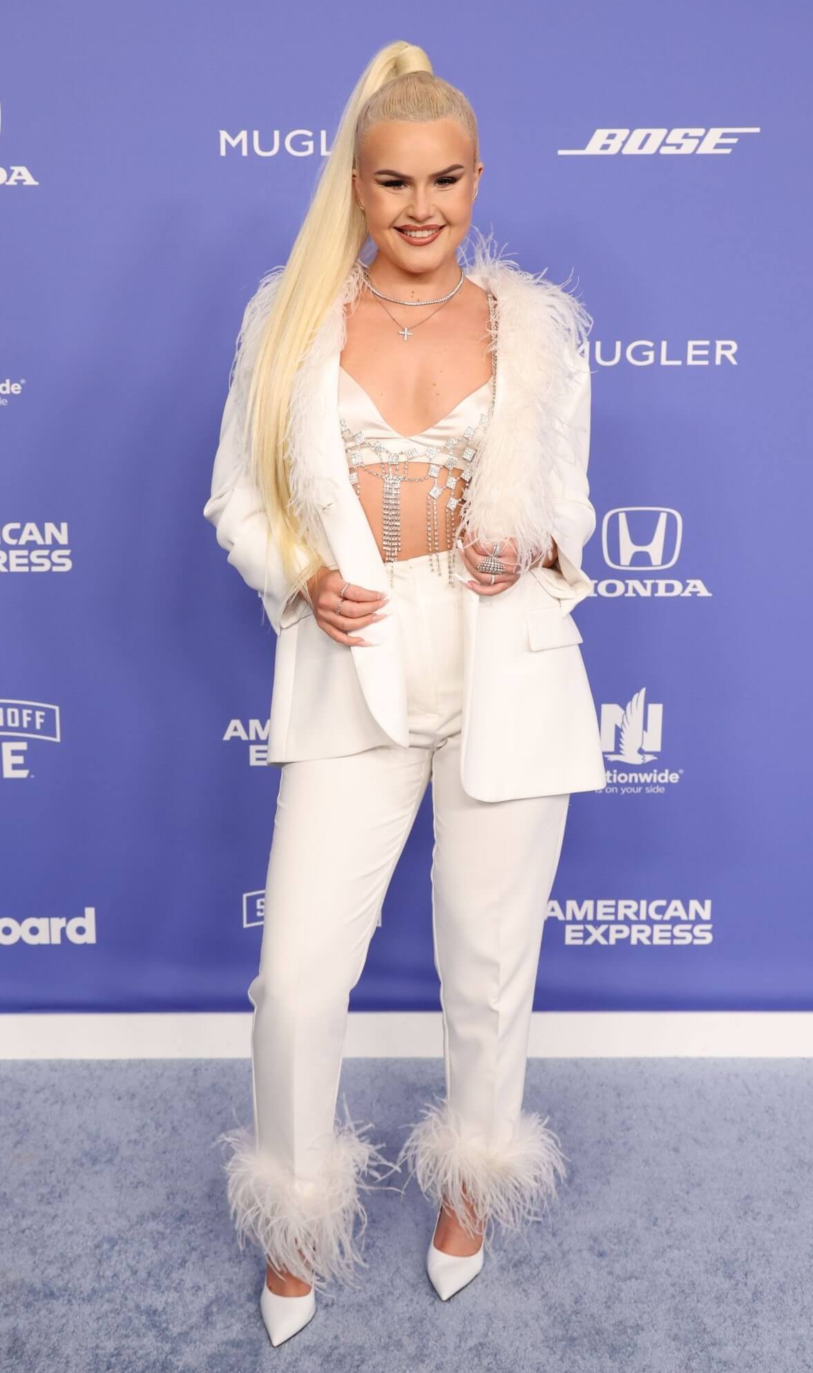 Ashlee Keating In White Fur Coat & Pants With Bralette Outfits At Billboard Women in Music Awards in Los Angeles