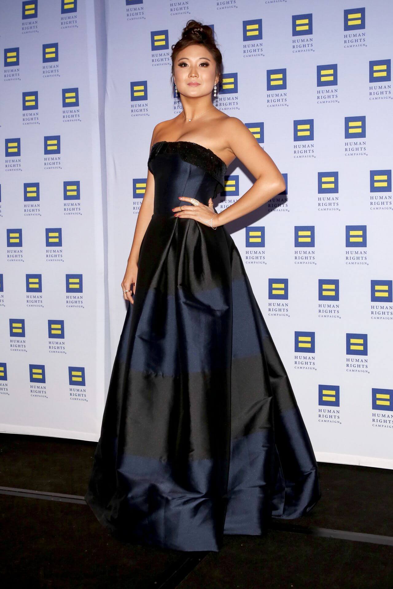 Ashley Park  In  shiny Black & Blue Fabric Strapless Long Flare Gown At HRC Greater New York Gala