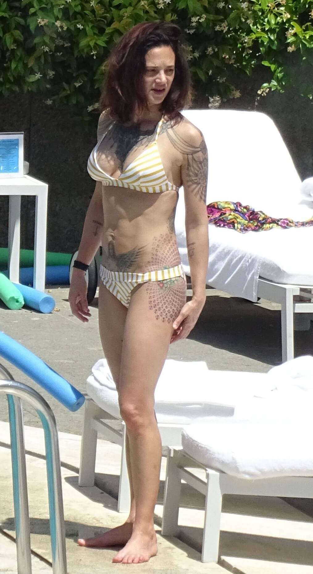 Asia Argento In Yellow Striped Bikini at the Hotel Hilton’s Swimming Pool in Rome