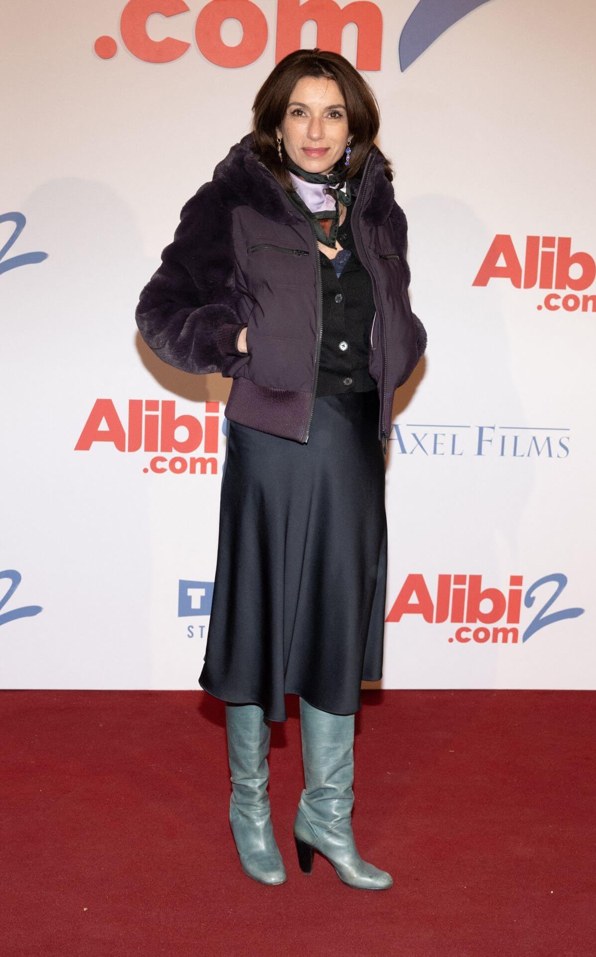 Aure Atika  In Black Top &  Skirt With Bomber Jacket At “Alibi.com 2” Premiere in Paris
