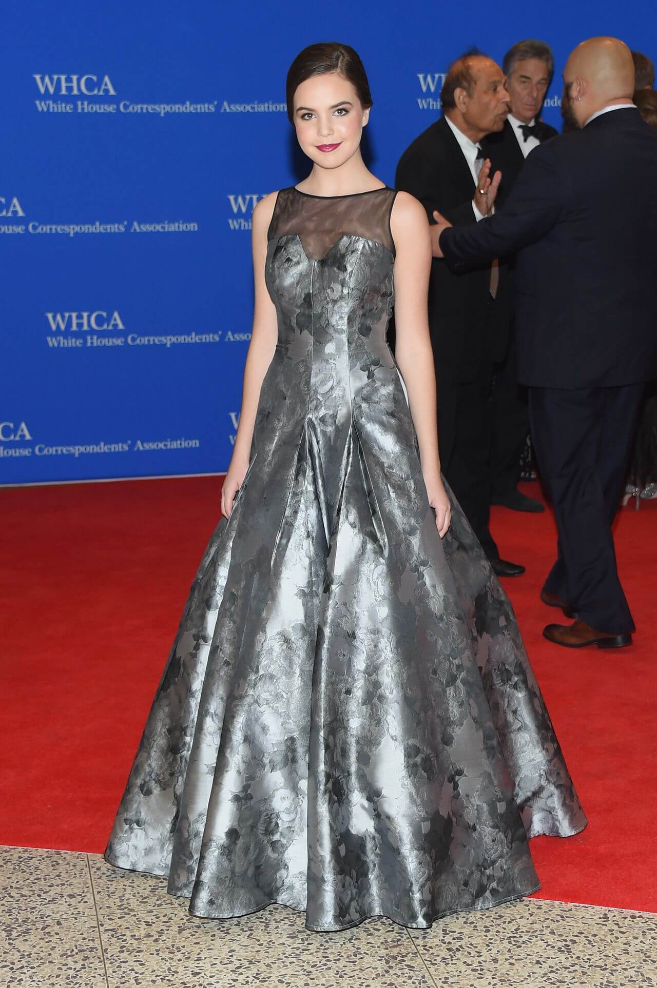 Bailee Madison In Shiny Grey Printed Sleeveless Long Flare Gown At White House Correspondents Dinner in Washington, DC