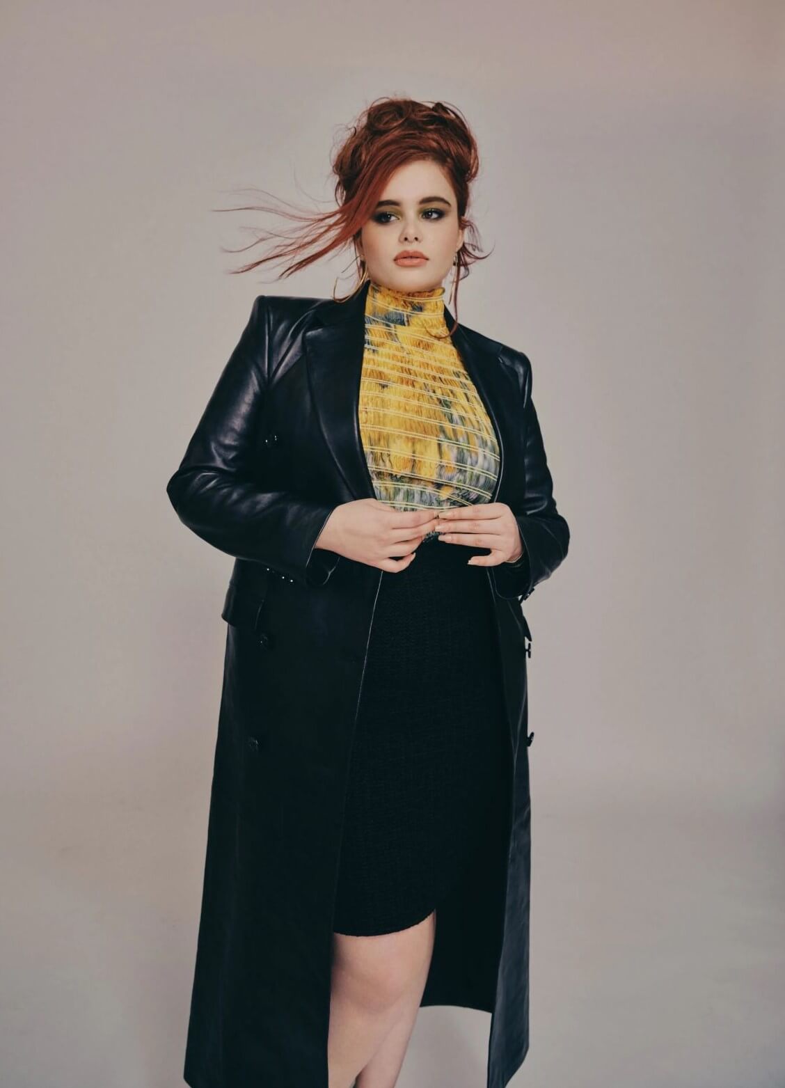 Barbie Ferreira  In Black Leather Long Jacket Under Yellow High Neck Top With Skirt Outfit