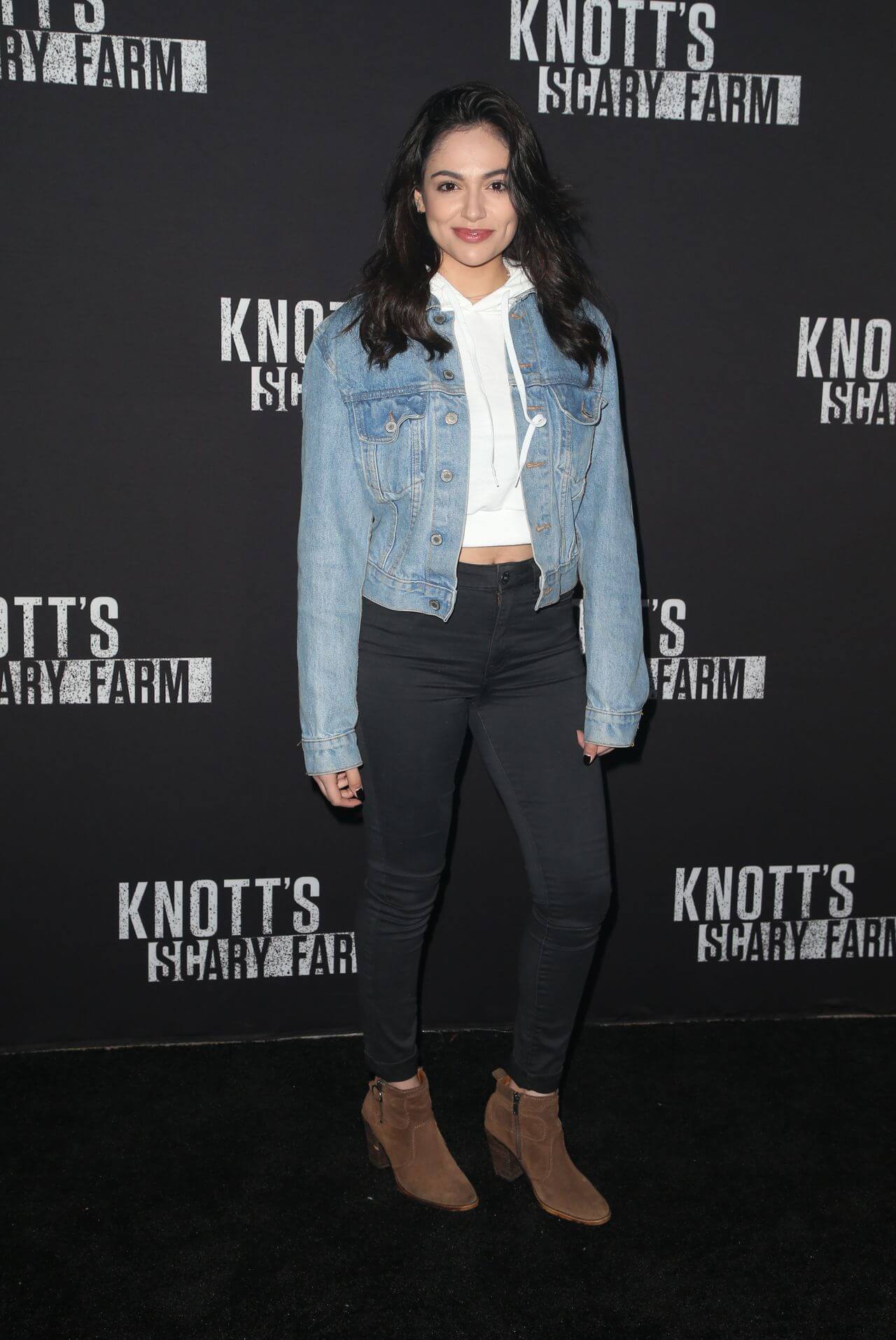 Bethany Mota In Blue Denim Jacket Under White Top With Black Jeans At Knott’s Scary Farm Celebrity Night in Buena Park