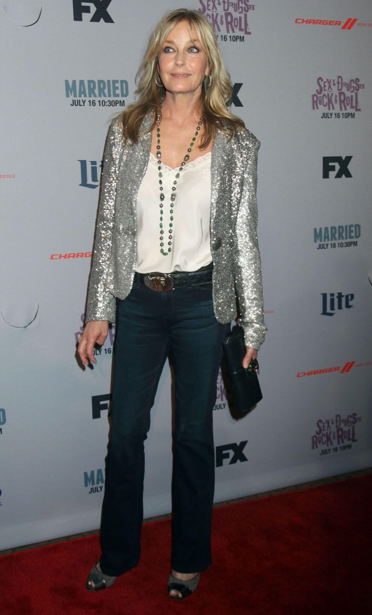 Bo Derek In a Grey Shimmery Jacket Under White Top With Denim Jeans Outfit