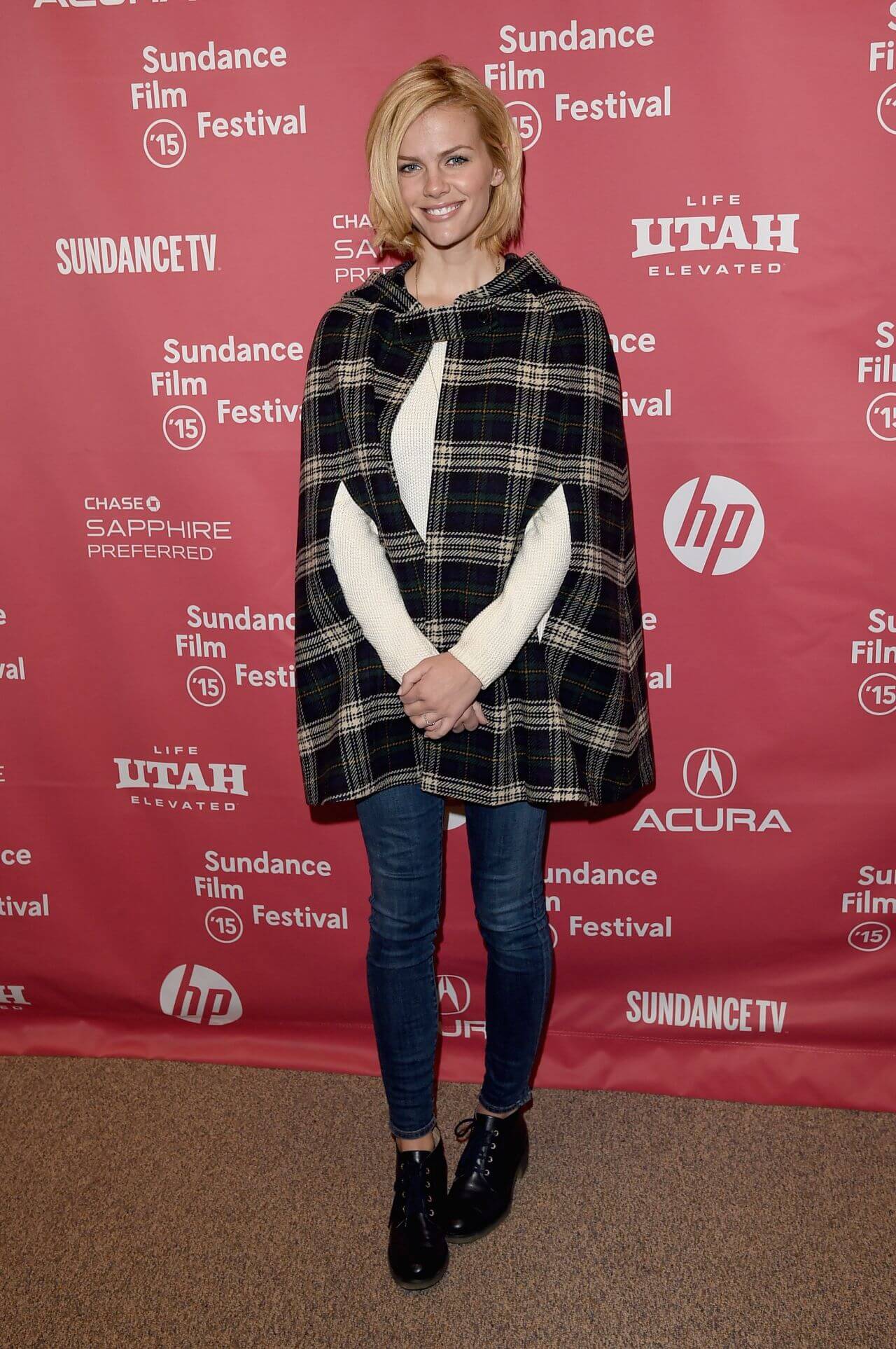 Brooklyn Decker  In Woven Checked Cut Out Coat Under White Pullover With Blue Jeans Outfit