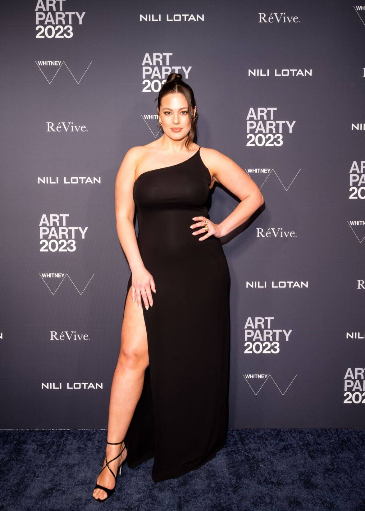 Ashley Graham In Black Asymmetrical Sleeves Long Slit Cut Dress At Whitney Art Party in New York
