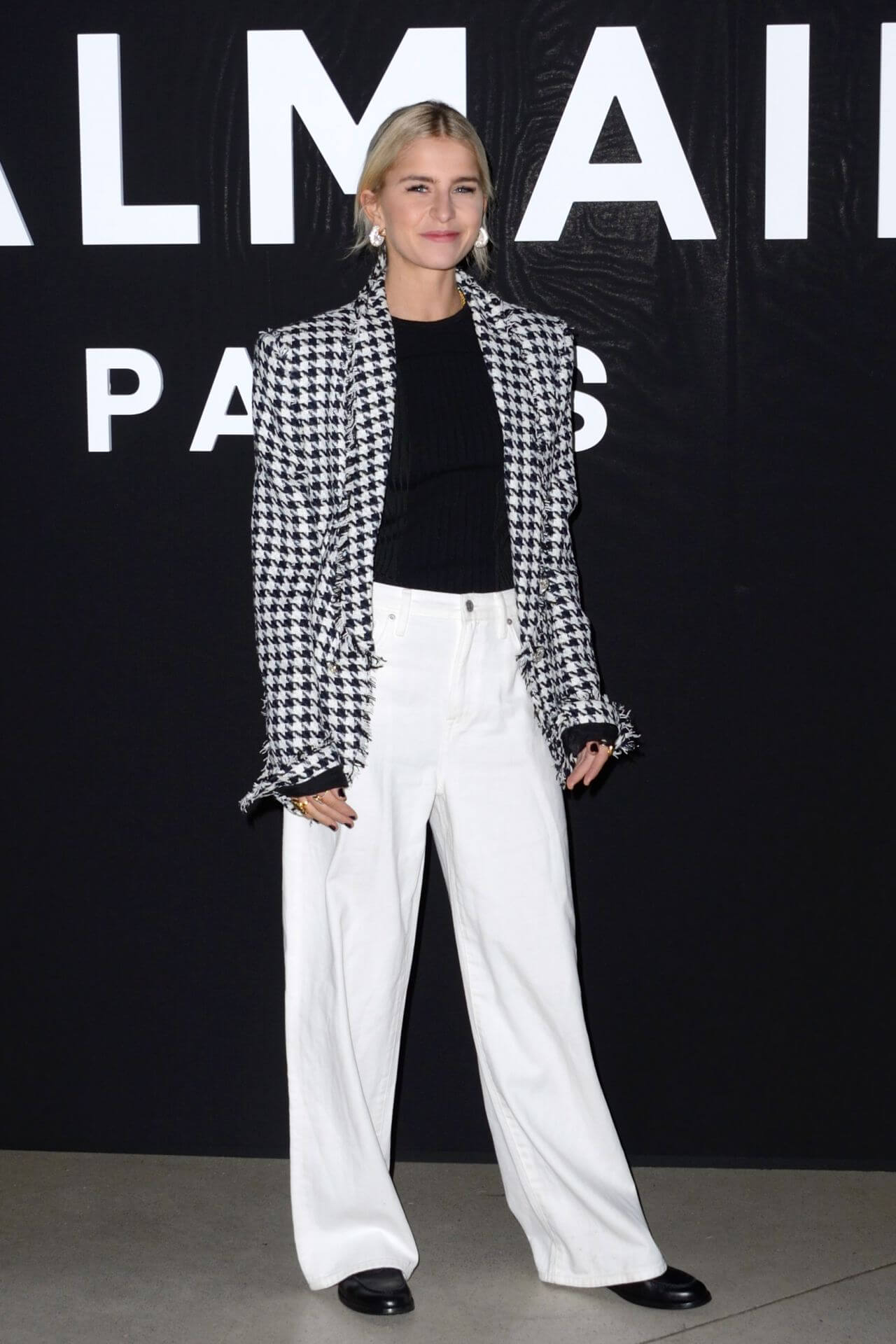Caroline Daur In Black  Checked Coat Under Top With White Pants At Balmain Fashion Show in Paris
