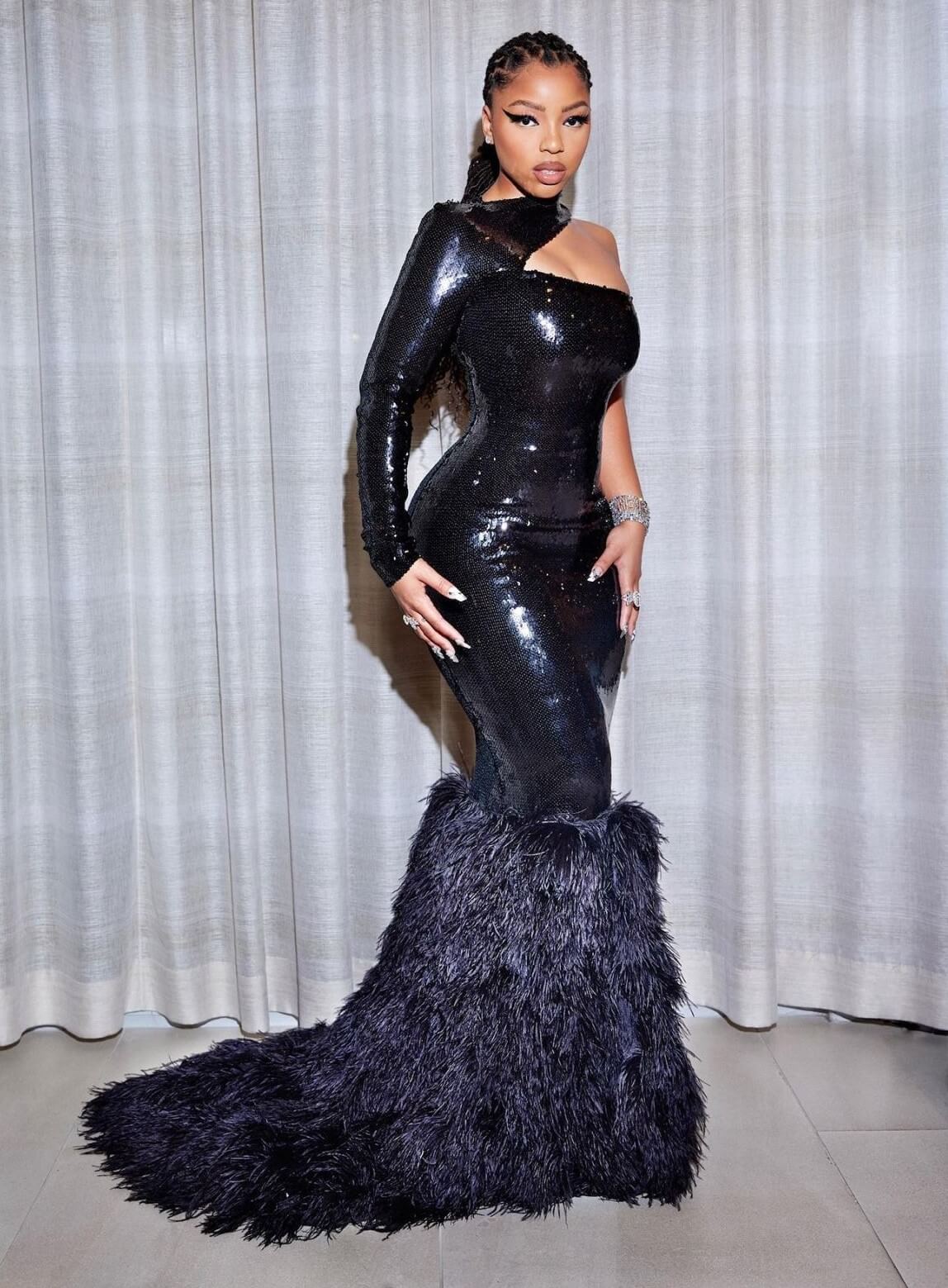 Chloe Bailey Bold Looks In Black Shiny Leather With Feather Style  Long Dress