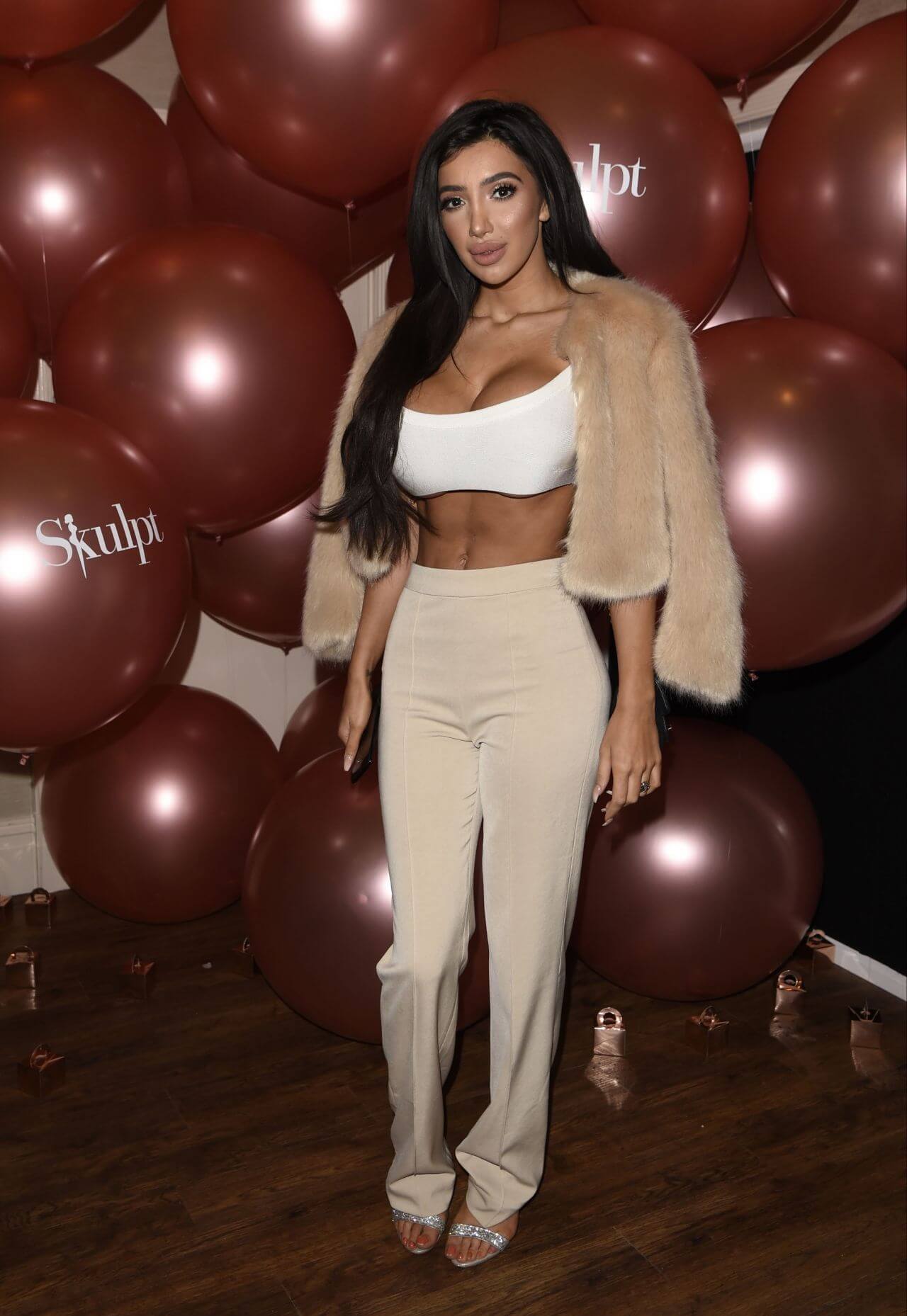 Chloe Khan In white Tube Top & Pants With Fur Jacket At Skulpt Non-Surgical Clinic First Birthday Party in Liverpool