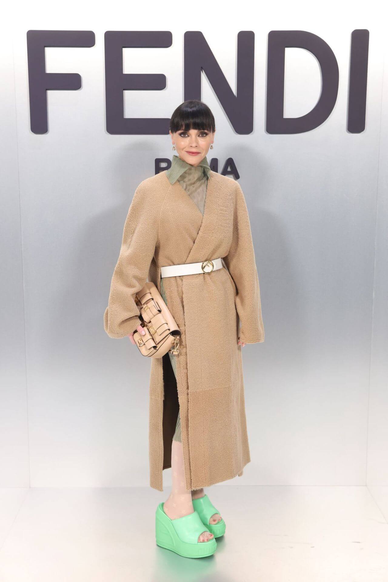 Christina Ricci In a Beige Woven Long Overcoat With a White Waist Belt  