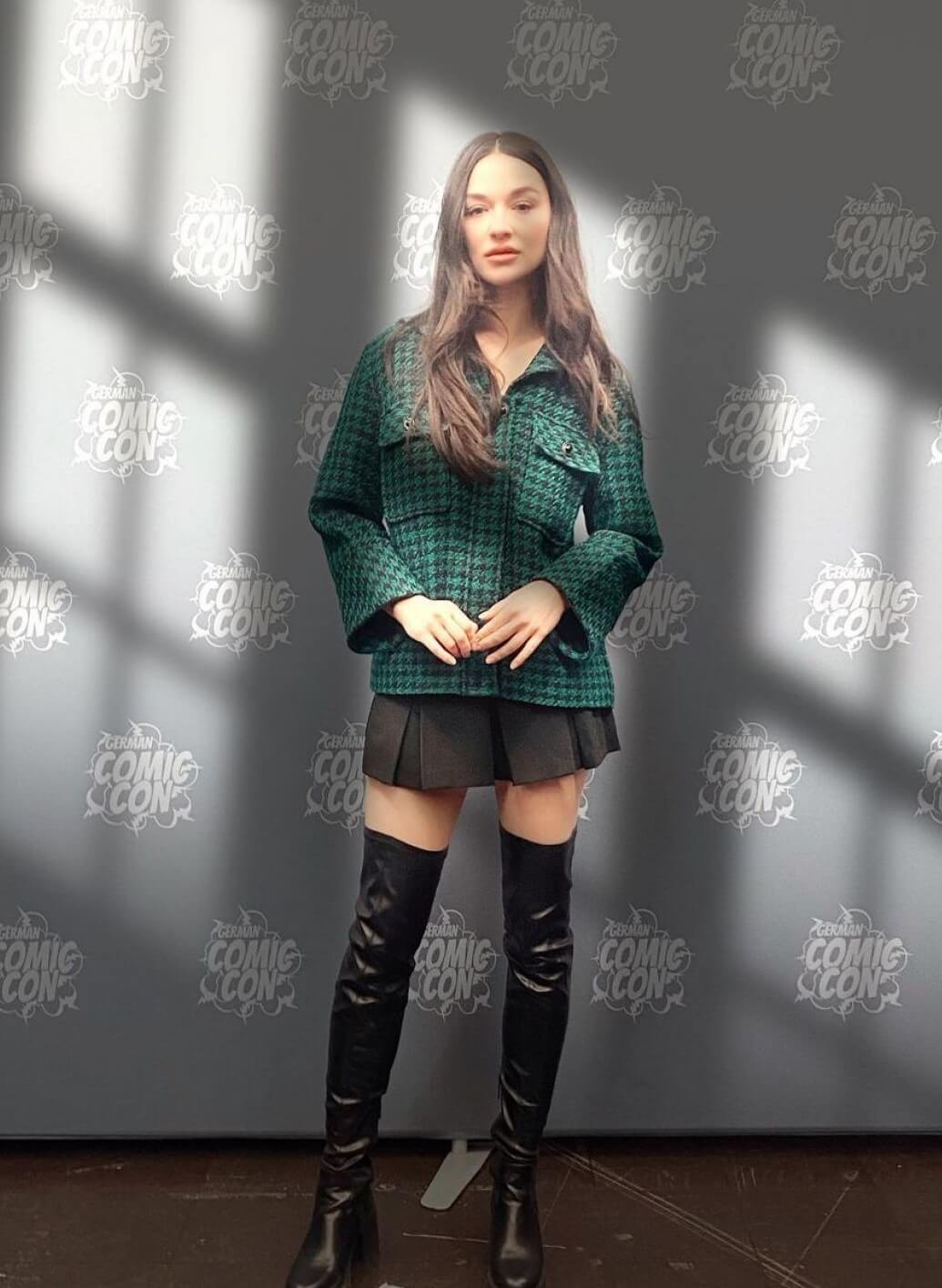 Crystal Reed  In Green Checked Coat & Pleated Mini Skirt With Black Long Boots At Photoshoot for German ComicCon