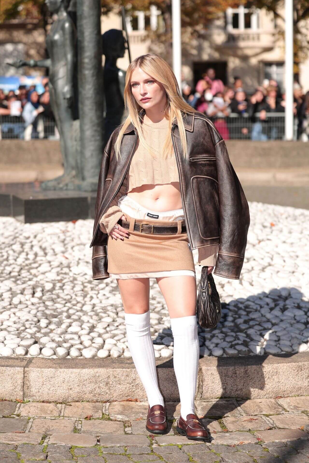 Camille Razat In Off White Crop Top & Mini Skirt With Leather Jacket At Miu Miu Show In Paris Fashion Week