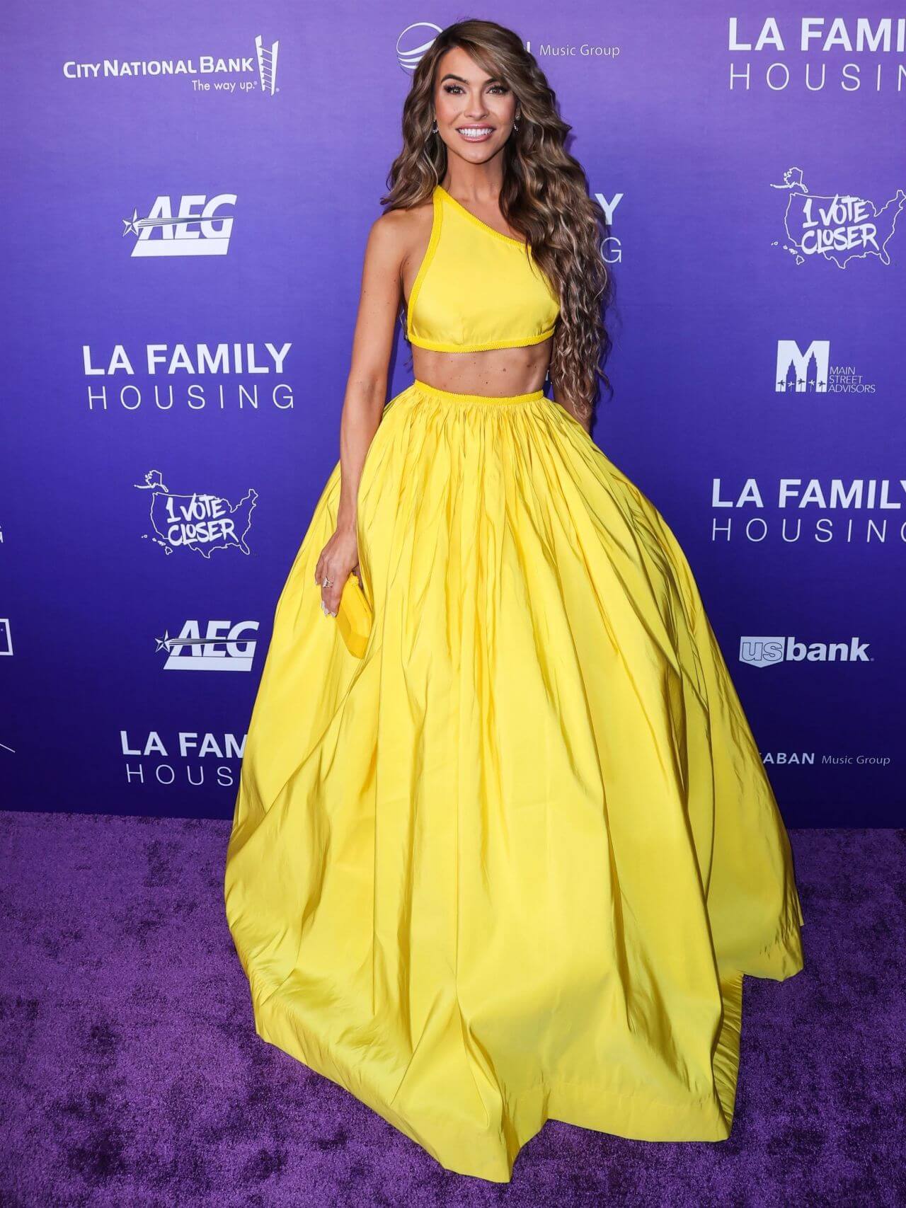 Chrishell Stause In Yellow Asymmetrical Sleeves Crop Top With Baggy Long Skirt Outfit At LA Family Housing (LAFH) Awards