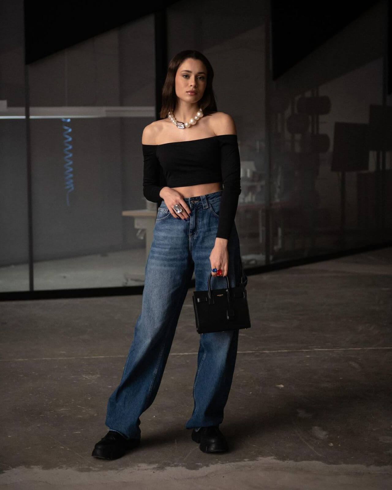 Daniela Melchior  In Black Off Shoulder Crop Top With Blue Baggy Jeans