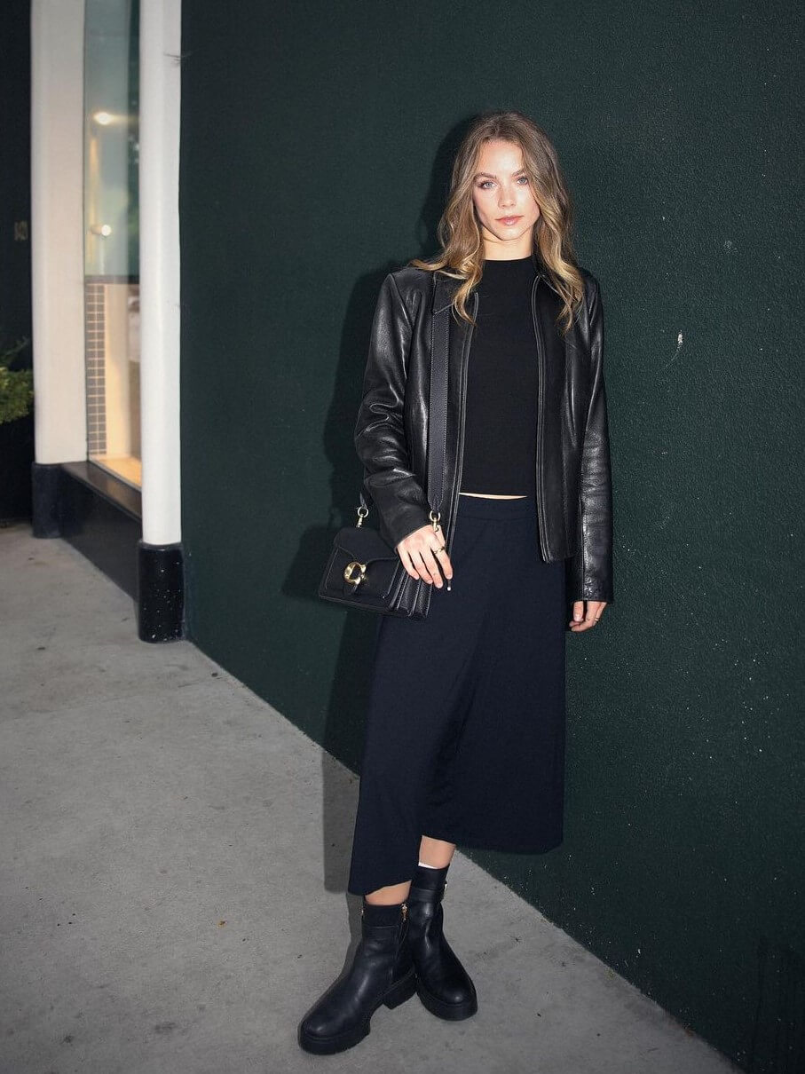 Anna Shumate In Black Top and Flare Pants With Leather Jacket