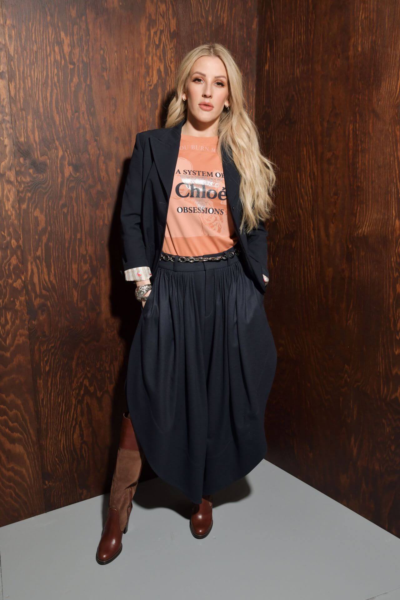 Ellie Goulding In Orange Top And Blazer With Pleated Skirt Outfit