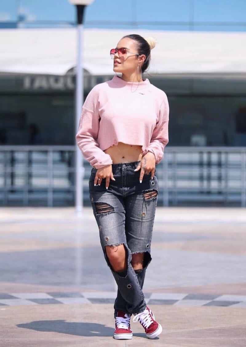 Karol G In Pink Crop Top With Ripped Jeans
